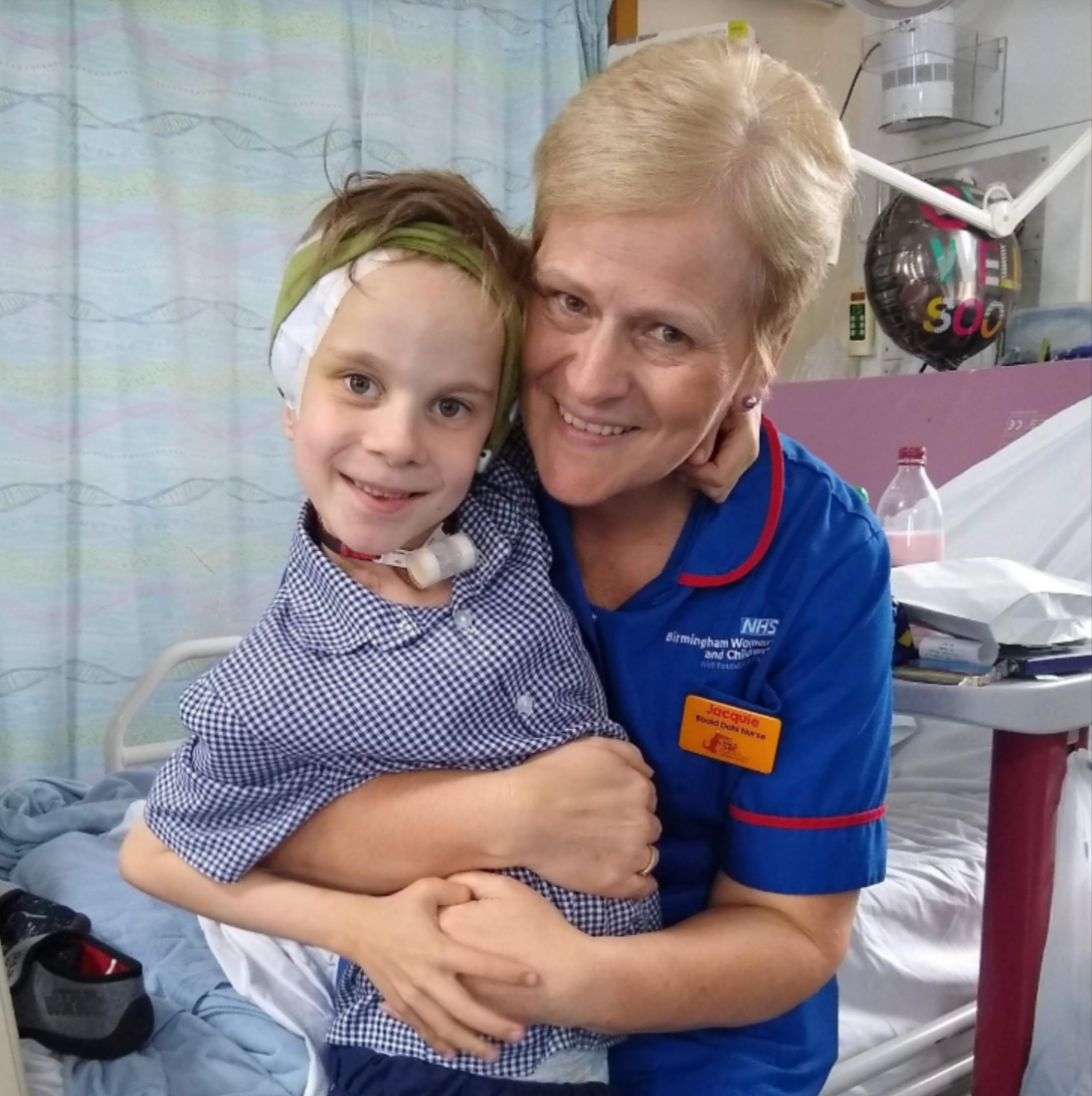 Nurse hugging a child.